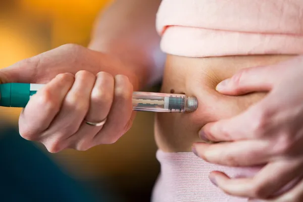woman giving herself an ivf injection