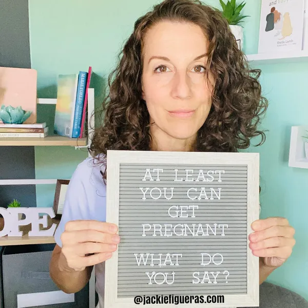 Nurse and miscarriage support specialist Jackie Figueras holding sign that reads "At least you can get pregnant. What do you say?"