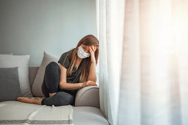 woman with hypochondria wearing a mask and researching medical conditions on her phone